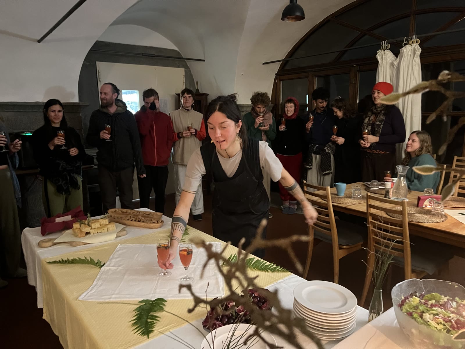 Menschen versammeln sich um einen festlich gedeckten Silvestertisch.